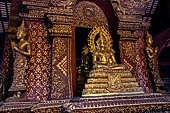 Chiang Mai - The Wat Phra Singh temple. The ubosot (ordination hall). Detail of the ku, a large ornate Buddha throne that sits in the middle of the building. 